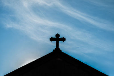 Low angle view of cross against sky