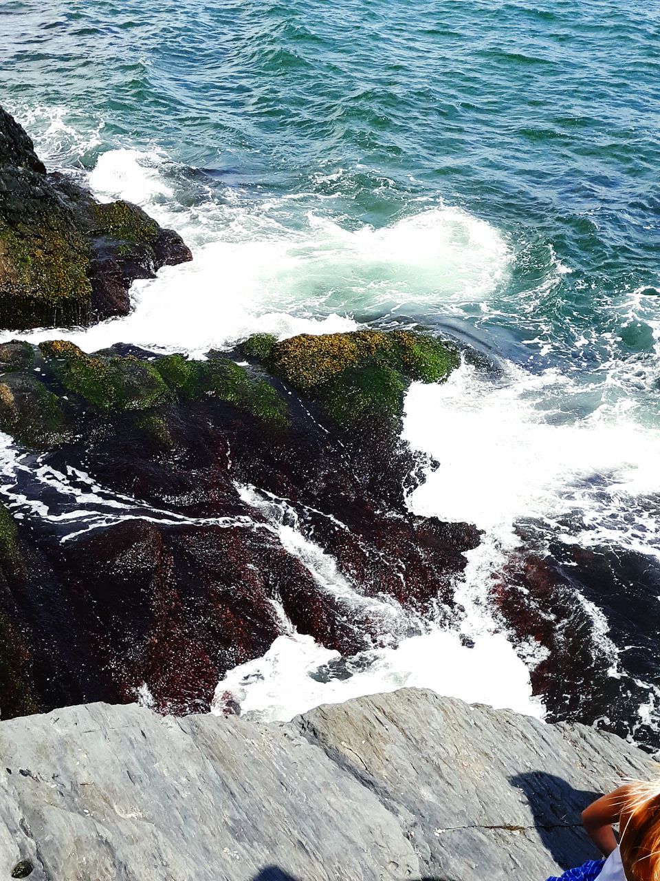 HIGH ANGLE VIEW OF WAVES SPLASHING ON ROCKS