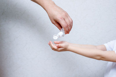 Midsection of woman holding hands over white background