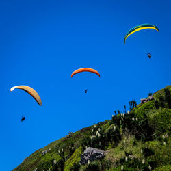 Low angle view of paragliding against clear sky