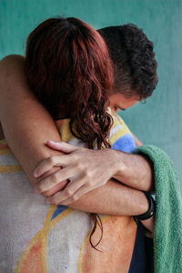 Couple embracing while wrapped in towel