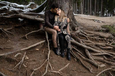 Full length of couple sitting on land