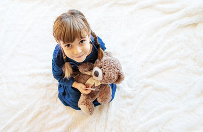 High angle view of cute girl with teddy bear