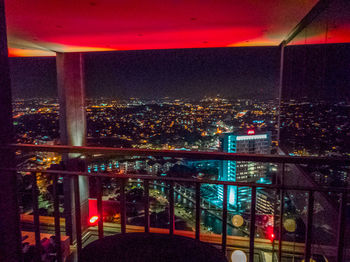 Illuminated cityscape against sky at night