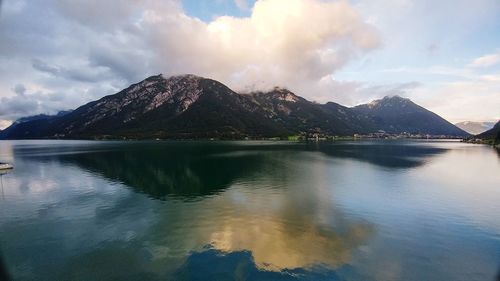 Scenic view of lake by mountains against sky