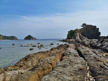 Rock formation on beach against sky