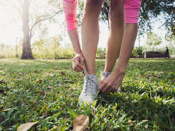 Low section of woman standing on field