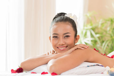 Portrait of smiling topless young woman relaxing at spa