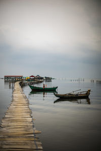 Fishing boat moored in sea against sky