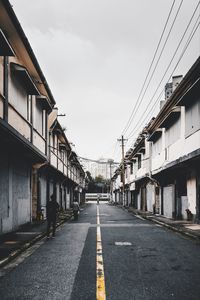 Road amidst buildings against sky in city