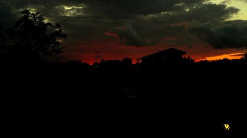 Silhouette of building against dramatic sky