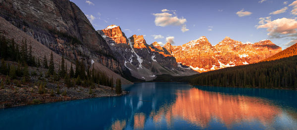 Scenic view of lake and mountains against cloudy sky