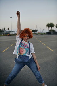 Young happy redhead girl dancing in the street