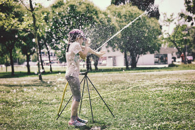Girl playing with sprinkler