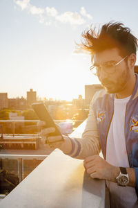 Young man using smart phone on a rooftop