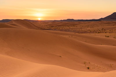 Scenic view of desert against sky during sunset