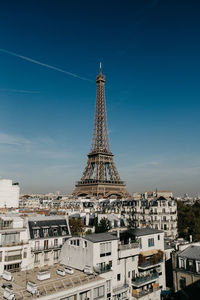 Tower of building in city against blue sky