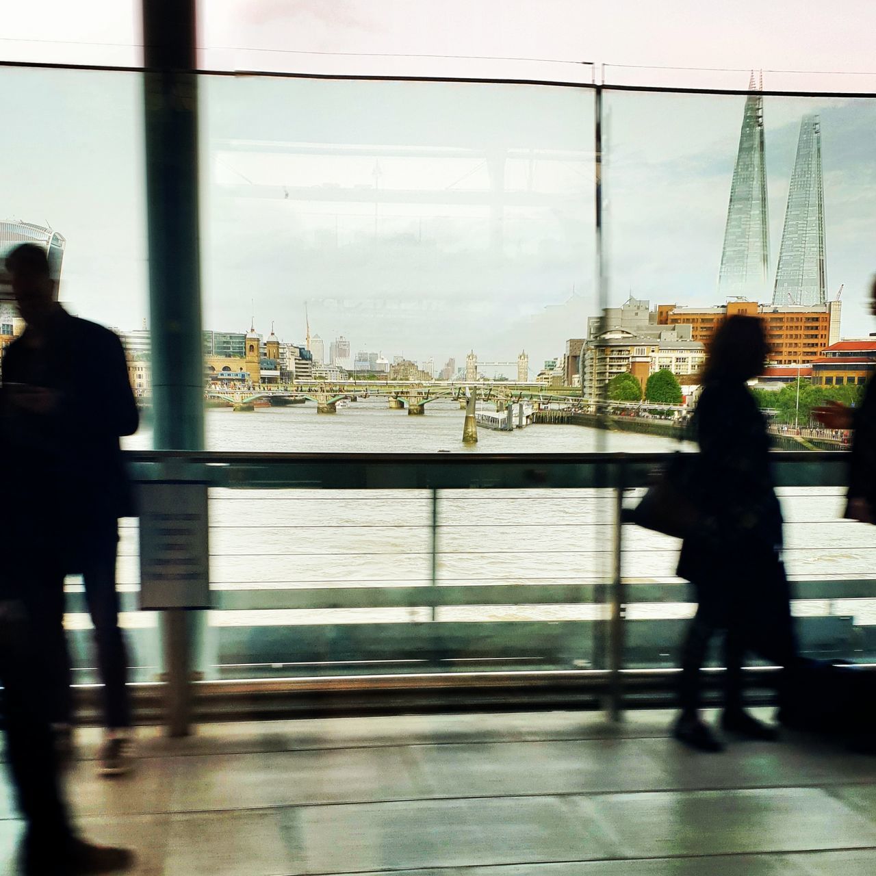 PEOPLE WALKING ON GLASS WINDOW