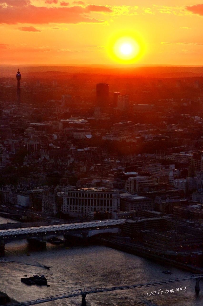 sunset, sun, orange color, building exterior, architecture, built structure, cityscape, sky, city, sunlight, scenics, high angle view, water, lens flare, nature, sunbeam, beauty in nature, river, outdoors, residential building