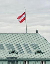 Low angle view of flag on building against sky