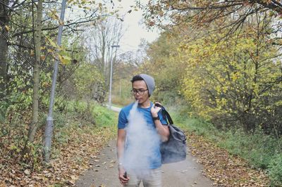 Man smoking while standing on footpath