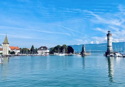 Buildings at waterfront against blue sky