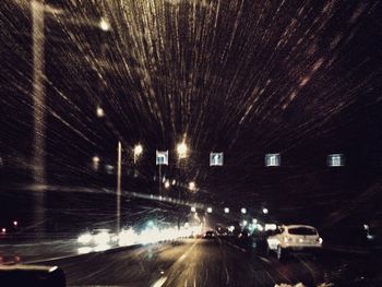 Cars on illuminated street at night