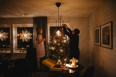 Father and daughter decorating christmas tree