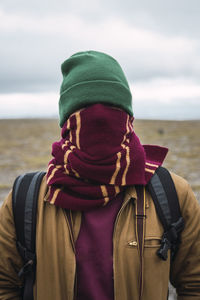 Young man with woolly hat and scarf, wrapped around face