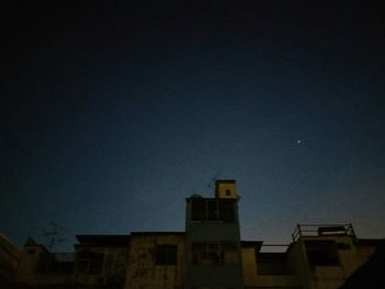 Low angle view of silhouette buildings against sky at night