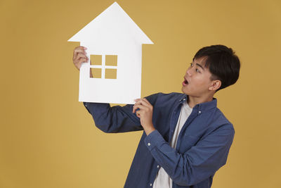 Man standing against yellow wall