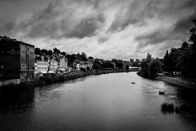 River amidst buildings in city against sky