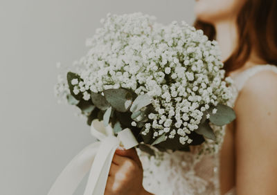 Portrait of a young unrecognizable caucasian bride with a bouquet of boutonnieres.