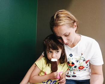 Mother embracing cute daughter at home