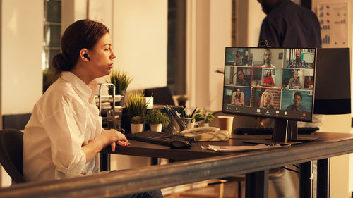 Side view of young woman working at home