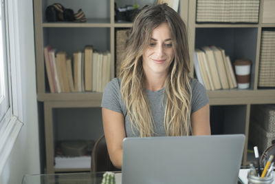 Young woman using laptop at table