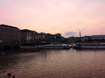 View of river and buildings against sky during sunset
