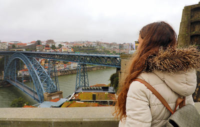 Rear view of woman against cityscape and sky