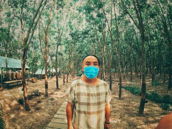 Portrait of man standing against trees