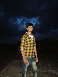 Portrait of young man standing on land against sky