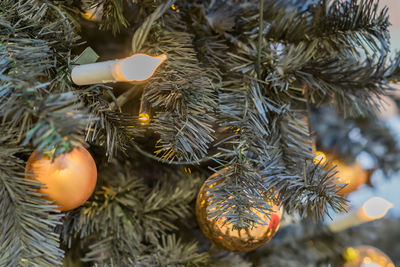 Christmas and new year holidays background. christmas tree decorated with gold balls and candle. 