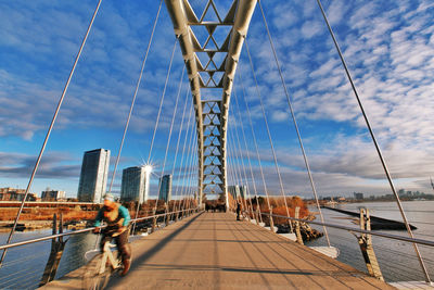 View of suspension bridge against cloudy sky