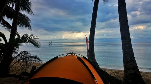 Scenic view of beach against cloudy sky