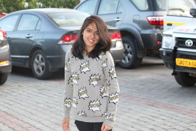 Portrait of woman standing on street in city