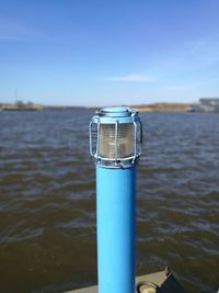 Close-up of bottle against blue sea