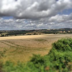 Scenic view of field against cloudy sky