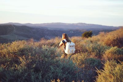 Full length rear view of woman standing on grassy field