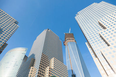 Low angle view of modern buildings against clear blue sky