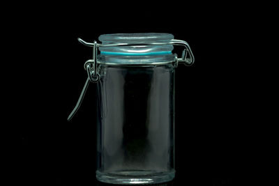 Close-up of glass jar on table against black background