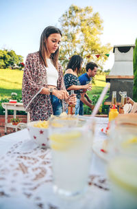 Young woman opening bottle at backyard